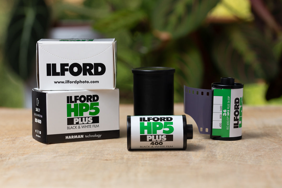 An image of several rolls of Ilford HP5 35mm film on a table.